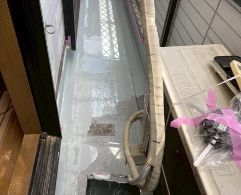 ベランダ床面にウレタン防水材1層目をローラーで塗布している施工中の様子。