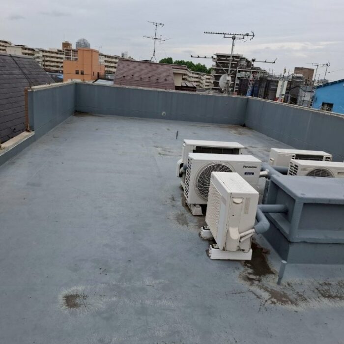 東京都北区の賃貸マンション屋上の防水施工前の状態。経年劣化により表面に汚れや色あせが見られる防水層。