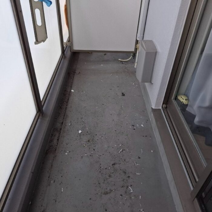 東京都江東区の賃貸マンションにて、トップコート施工前のベランダ床面。既存ウレタン防水層に退色や摩耗が見られる状態